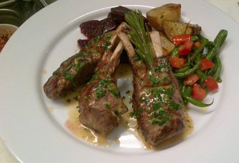 A candlelit table at da Salvatore Restaurant, with a white-clothed interior and a grand piano under warm lighting.