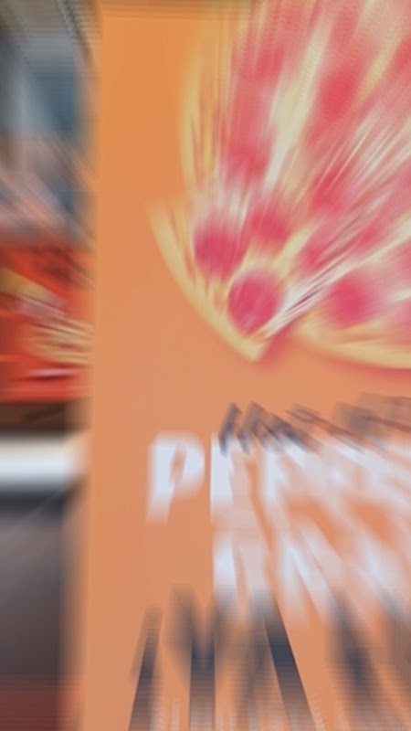 Pizzería Suprema – close‑up of the Suprema Special slice with caramelised onions, spicy honey drizzle, and crisp bacon on a thin crust