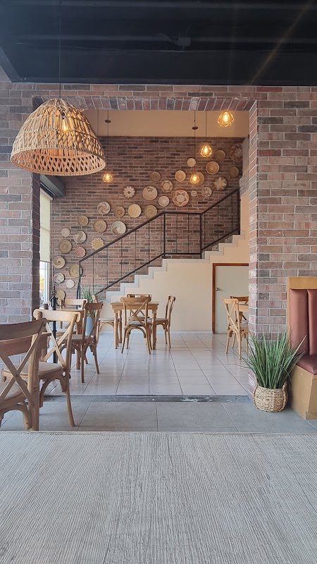 Interior de MINUZ con mesas ocupadas y comida en el mostrador