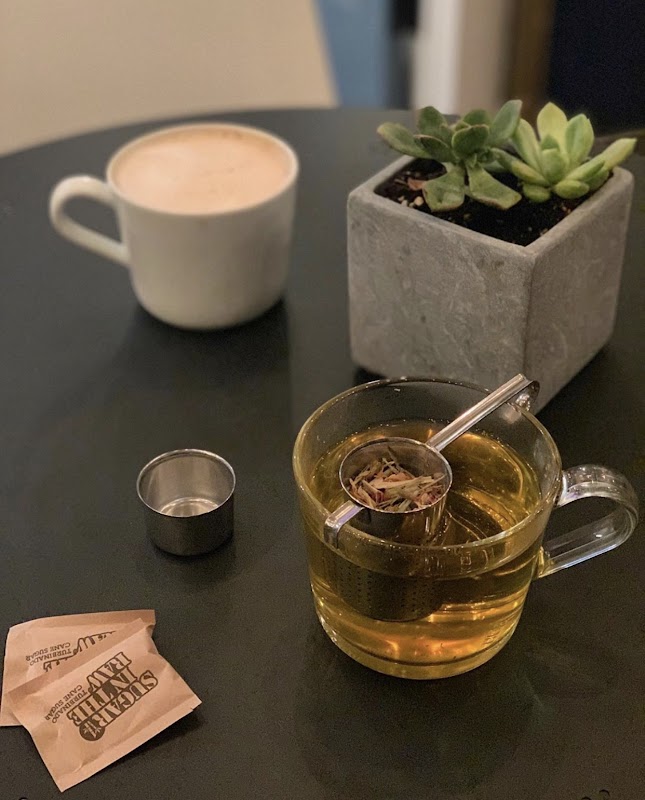 Modern coffee bar with greenery and tables
