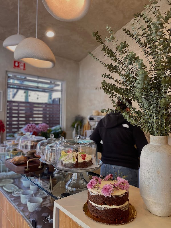 ANDALUCÍA Café – bright interior with plants, a plate of chilaquiles next to a fluffy waffle and a steaming coffee on the counter