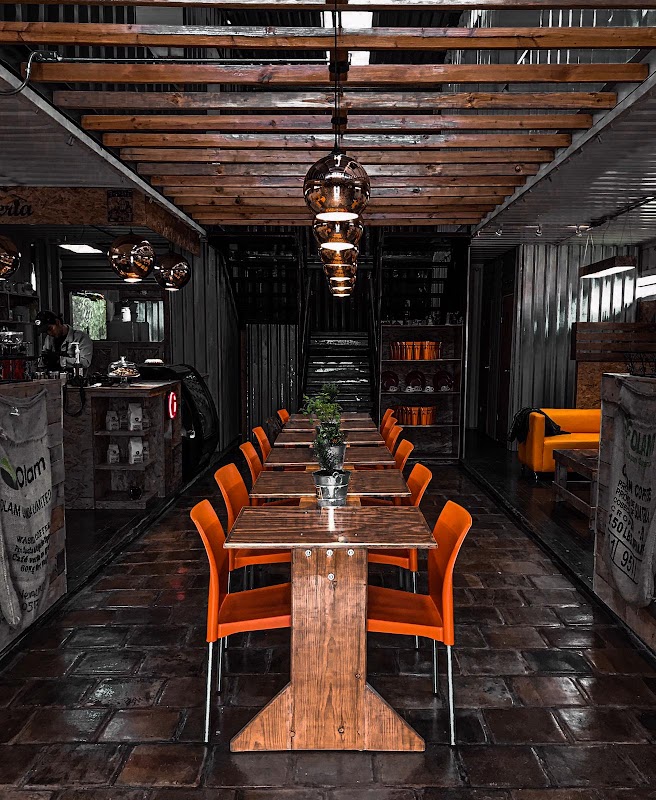 Terraza del ANDALUCÍA Café con plantas y sillas blancas