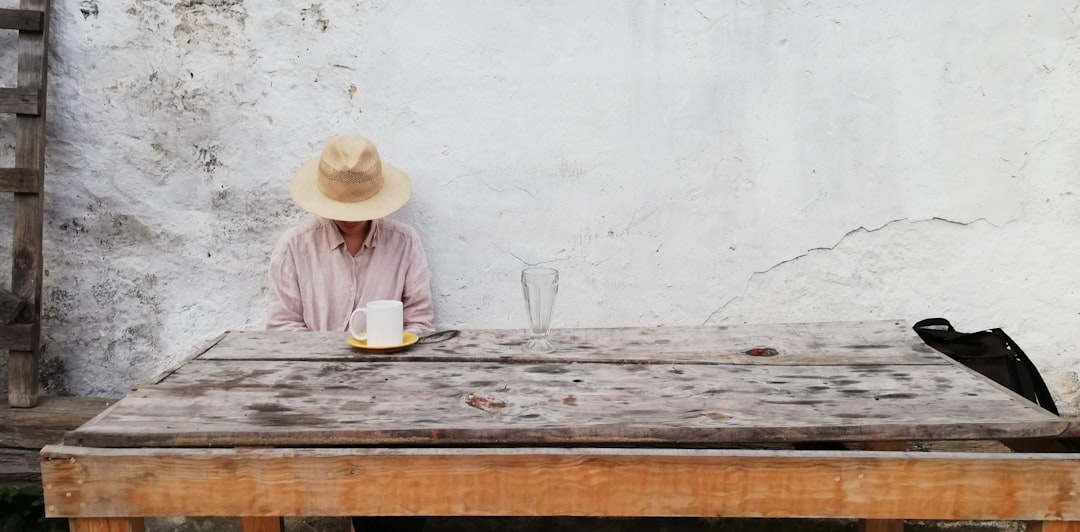 a person sitting at a table with a hat on